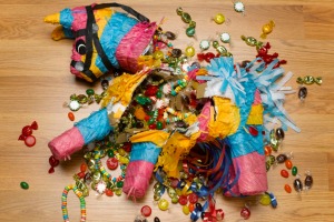 Smashed donkey pinata on floor with candy